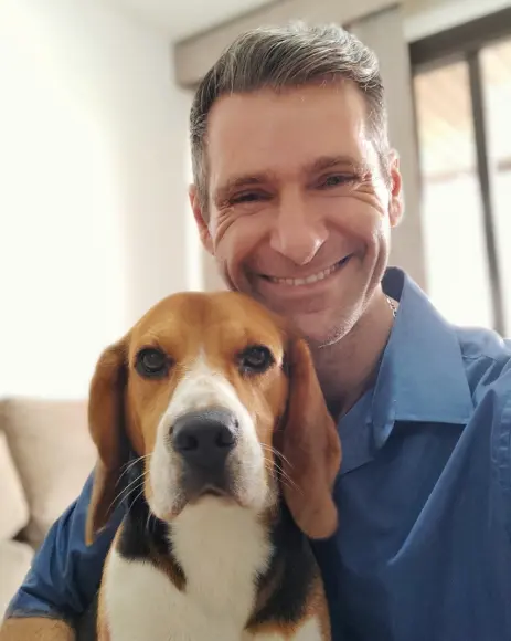 Ricardo Tamborini, especialista em comportamento canino, ao lado de um cão Beagle