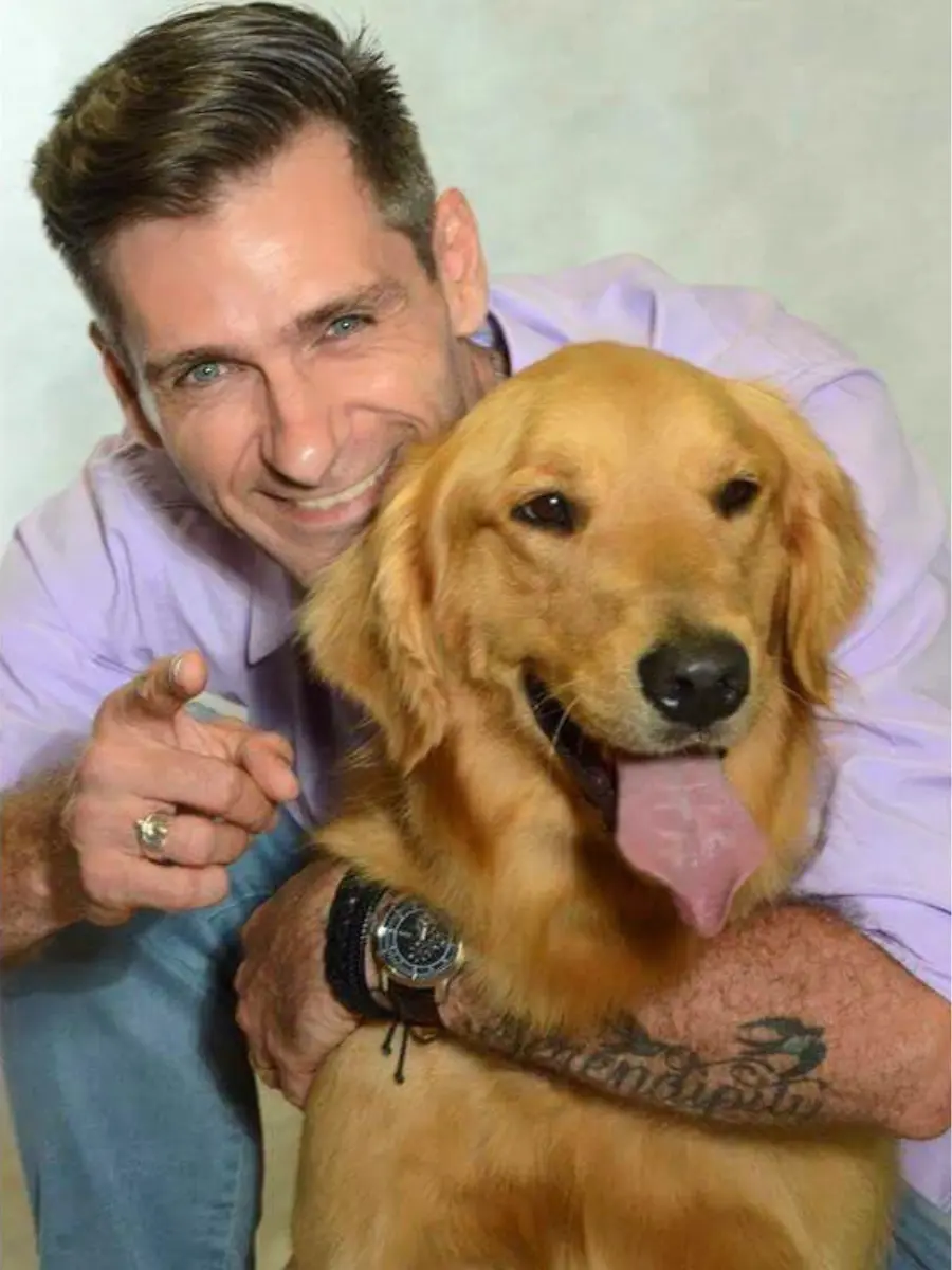 Ricardo Tamborini ao lado de um cão Golden Retriever